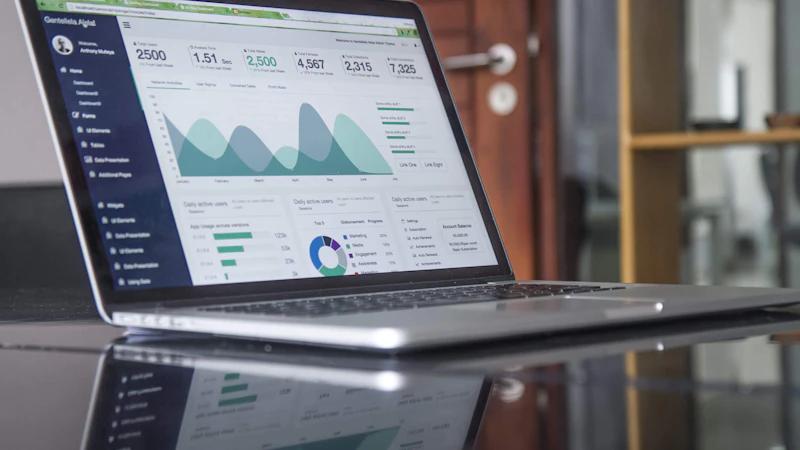 Trader analizando gráficos y datos de rendimiento en ordenador portátil — proceso estructurado de revisión de operaciones